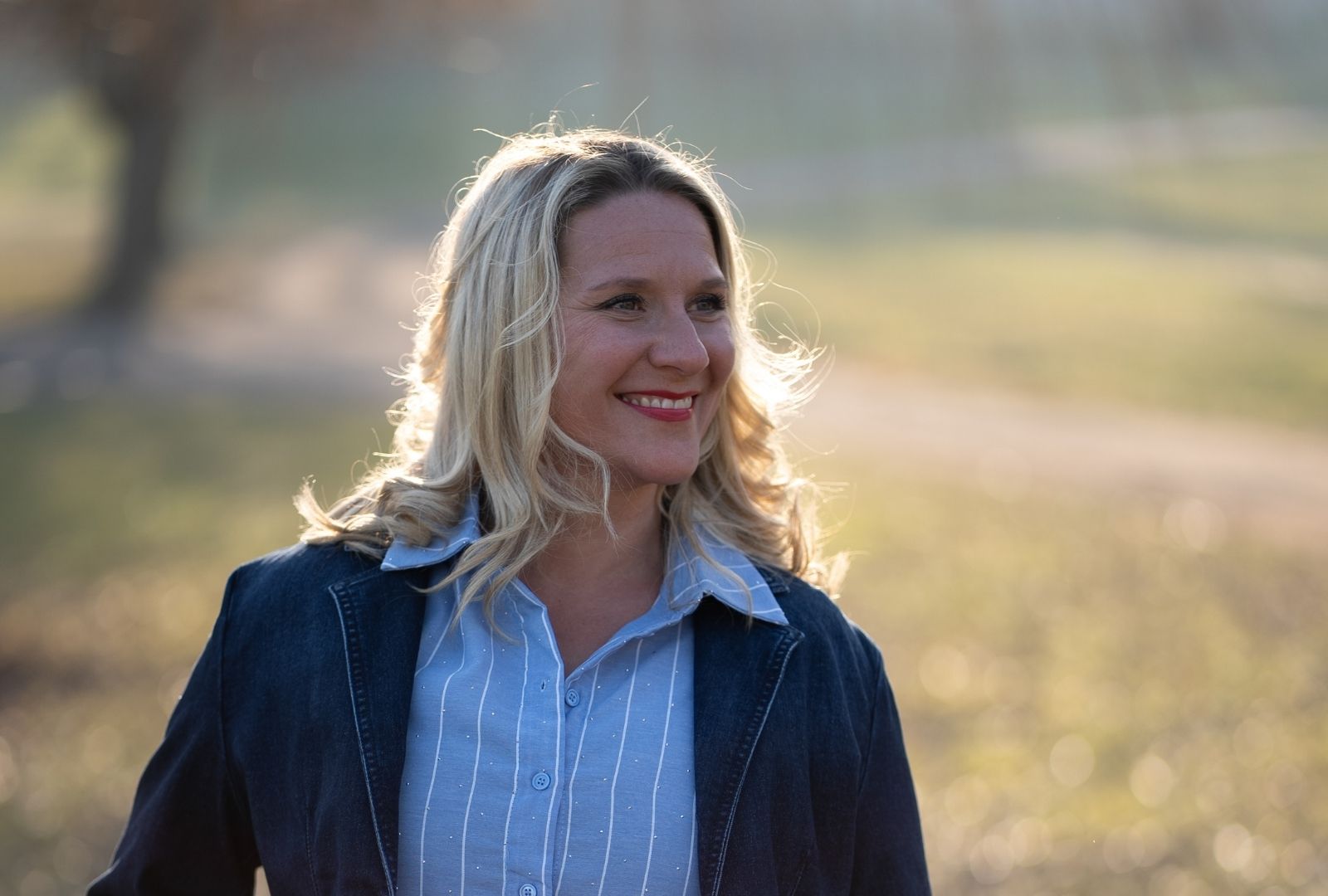 Jessica Ludwig, Mitgründerin von Kairos WirkRaum, lächelt im warmen Abendlicht im Freien.